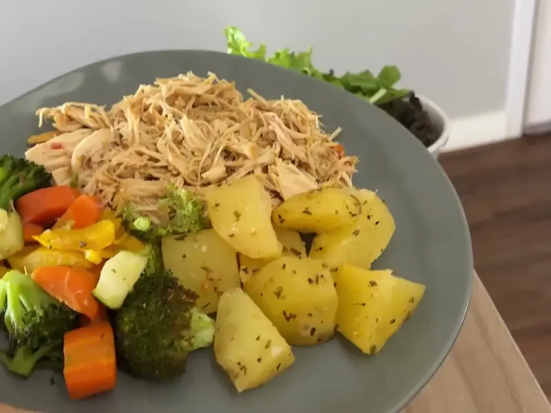 Prato com frango desfiado, batatas e legumes no vapor